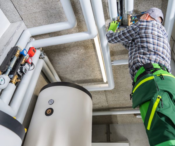 Residential and Commercial Modern Natural Gas Heating Systems Installation Performed by Professional Caucasian HVAC Technician in His 40s.